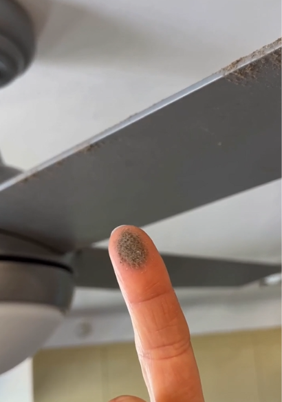 Finger covered in dust after touching a ceiling fan blade